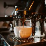 espresso machine pouring coffee into cups